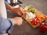 Un hombre cortando vegetales en la cocina