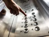 Un dedo pulsando una tecla en un ascensor.
