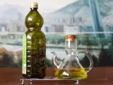 Una botella y una aceitera con aceite de oliva virgen.