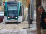 Un ciudadano, junto al tranvía de Barcelona.