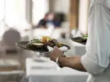 Un camarero sirviendo un plato en un restaurante.