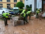 Policías armados realizan labores de dragado en una calle inundada mientras el tifón Haikui provoca fuertes lluvias el 5 de septiembre de 2023 en Fuzhou, provincia china de Fujian.