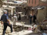 Varios hombres caminan por las calles de Amizmiz, situada a unos 30 kilómetros del epicentro del terremoto, en las faldas del Atlas, que amaneció este sábado llena de cascotes y escombros de edificios derruidos.