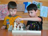Niños jugando una partida de ajedrez.