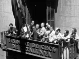 Lluís Companys, presidente de la Generalitat, iza la bandera catalana en el balcón de la sede del Sindicat de Cecs.