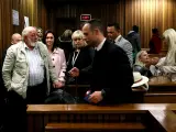 Barry Steenkamp, con chaqueta beige, en un día del juicio a Oscar Pistorius, en primer término con traje oscuro.