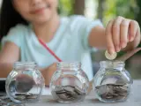 Imagen de archivo de una niña con monedas.