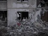 Dos niños de 11 años miran el exterior desde los escombros de un edificio tras un ataque ruso a la ciudad de Járkov.
