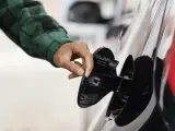 Un conductor mira su depósito para comprobar si tiene gasolina o no