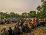 Migrantes esperan afuera del centro de atención mientras intentan avanzar hacia la frontera norte para obtener un permiso de residencia e ingresar al país en Tapachula, México.