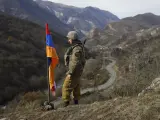 Un soldado monta guardia junto a la bandera de Nagorno-Karabaj.
