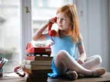 Una niña instruida en los secretos de la comunicación telefónica.