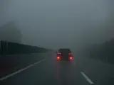 Un coche circula con la luz antiniebla trasera encendida.