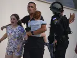 Agentes de policía israelíes evacuan a una familia de un lugar alcanzado por un cohete disparado desde la Franja de Gaza, en Ashkelon, en el sur de Israel.