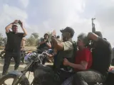 Varios milicianos palestinos transportan a un civil israelí capturado, en el centro, desde el kibutz Kfar Azza hasta la Franja de Gaza.
