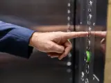 Una persona pulsa el piso en un ascensor