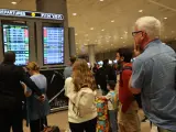 Varios pasajeros miran atentamente una pantalla que informa de las salidas en el aeropuerto Ben Gurion, cerca de Tel Aviv, donde se han cancelado numerosos vuelos tras el ataque de Hamás.