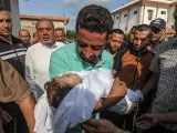 Un padre palestino lleva en brazos a su hijo de 3 años, fallecido durante los ataques en Gaza.