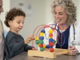 Un pediatra observa a un niño con retraso madurativo.