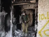 Un soldado israel&iacute; inspecciona una casa destruida.