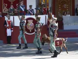 La princesa de Asturias, Leonor (i-d), el rey Felipe VI y la reina Letizia, al paso de Pacoli, la cabra de la Legión, durante el desfile del Día de la Fiesta Nacional en Madrid.