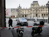 Vista exterior del Museo del Louvre en París, acordonado y bajo vigilancia policial tras ser evacuado.