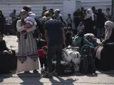 Palestinos esperan para cruzar a Egipto por el paso de Rafah.