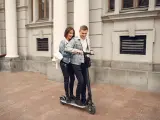 Dos personas circulan de manera ilegal sobre un patinete.