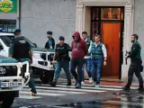 La Guardia Civil y el detenido salen de la vivienda que ha sido registrada, en A Gándara, Narón.