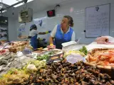 Una mujer atiende su puesto en una pescadería de la Praza de Abastos y de Frigsa en Lugo.