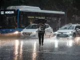 Una persona cruza la calle bajo la lluvia de Madrid
