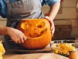 Persona cortando una calabaza para Halloween