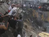 Palestinos sacan a un ni&ntilde;o de entre los escombros tras un ataque israel&iacute; contra la Franja de Gaza.