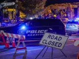 Un coche de policía controla una de las calles cortadas, en Lewiston (EE UU), tras el doble tiroteo que se ha producido en una bolera y un restaurante de un centro comercial de la localidad.