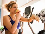 Mujer joven come una manzana después de entrenar.