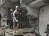 Varios ciudadanos palestinos expresan desesperación después de que su vivienda haya sido destruida en un bombardeo israelí en la Franja de Gaza.