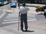 Un hombre mayor pasea apoyándose en un bastón, a 24 de julio de 2023, en Madrid (España).