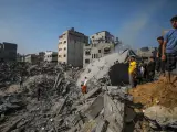 Palestinos buscan cuerpos entre los escombros tras el ataque al campo de refugiados de Jabalia.