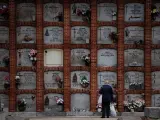 Una mujer delante de varios nichos en el cementerio de la Almudena, a 1 de noviembre de 2023, en Madrid (España).