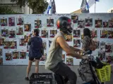 Familiares de los rehenes cuelgan sus fotos en un mural en Tel Aviv