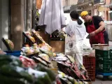 Un trabajador de una pyme atiende su pequeño comercio en Barcelona.