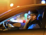 Un conductor bosteza mientras conduce de noche.