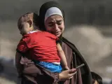 Una mujer se abraza a su bebé en Gaza.
