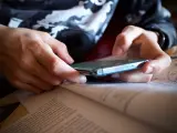Un estudiante utiliza un móvil mientras estudia