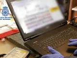 Un agente revisando un portátil con contenido pornográfico infantil.