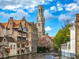 Belgium, Bruges - September 26, 2015: View from the Rozenhoedkaai in Bruges with the Perez de Malvenda house and Belfort van Bruges in the background and number of peoples in the boats.