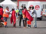 Trabajadores de la Cruz Roja tapan con mantas a los m&aacute;s de 170 migrantes que han llegado al Puerto de la Restinga de El Hierro