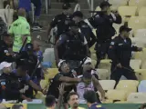 Agentes de la Polic&iacute;a brasile&ntilde;a cargan en una de las gradas de Maraca&ntilde;a para separar a los aficionados que estaban involucrados en una trifulca antes del inicio del partido.