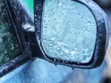 Un retrovisor lleno de gotas de lluvia.