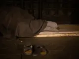 Un hombre sin hogar duerme en el Paseo de Gracia con Gran Vía de Les Corts Catalans.